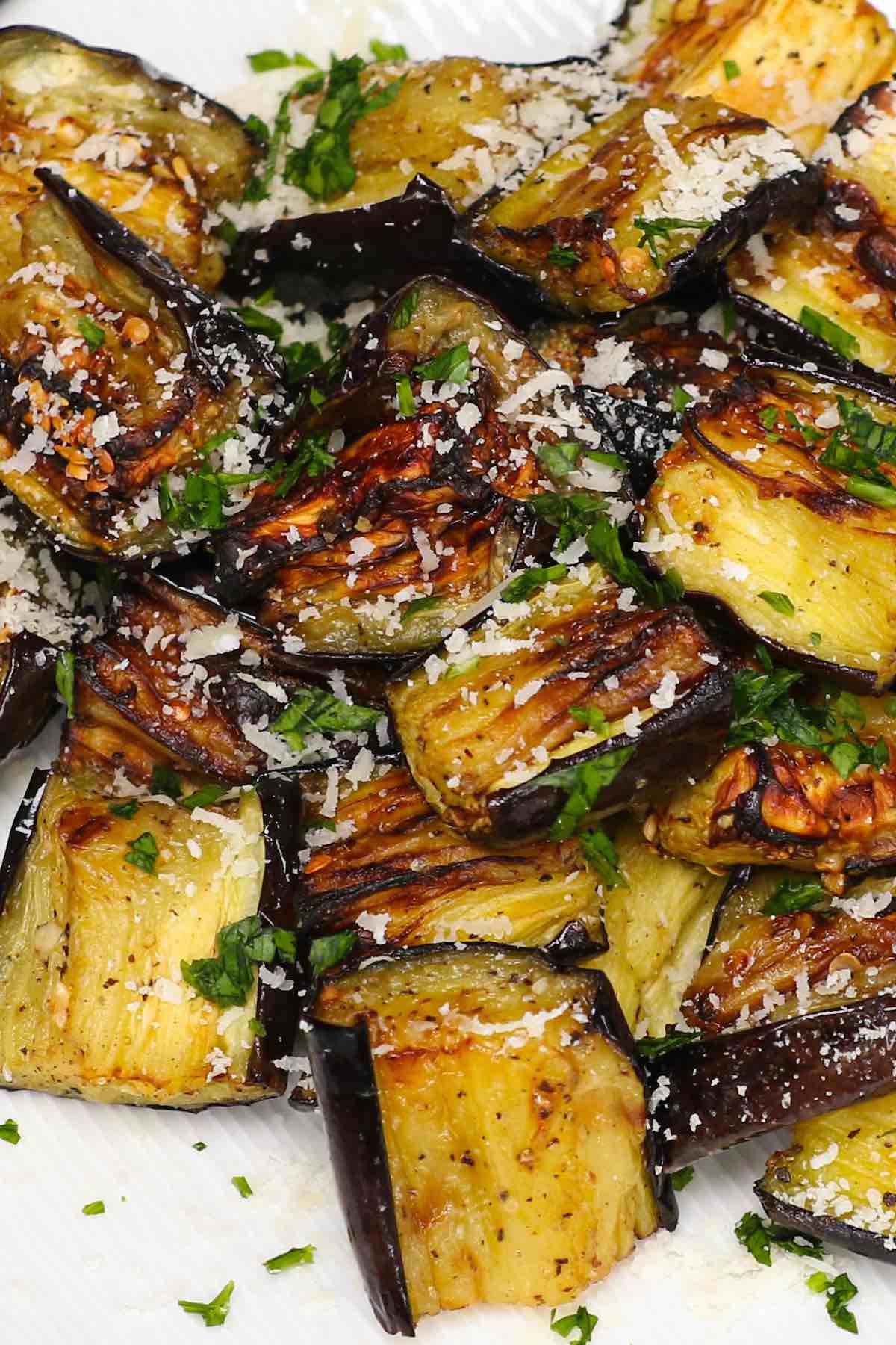 Air Fryer Eggplant on a serving plate garnished with grated parmesan and parsley.