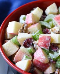 Crunchy apple salad in a serving bowl made with Fuji apples, walnuts, celery and cranberries