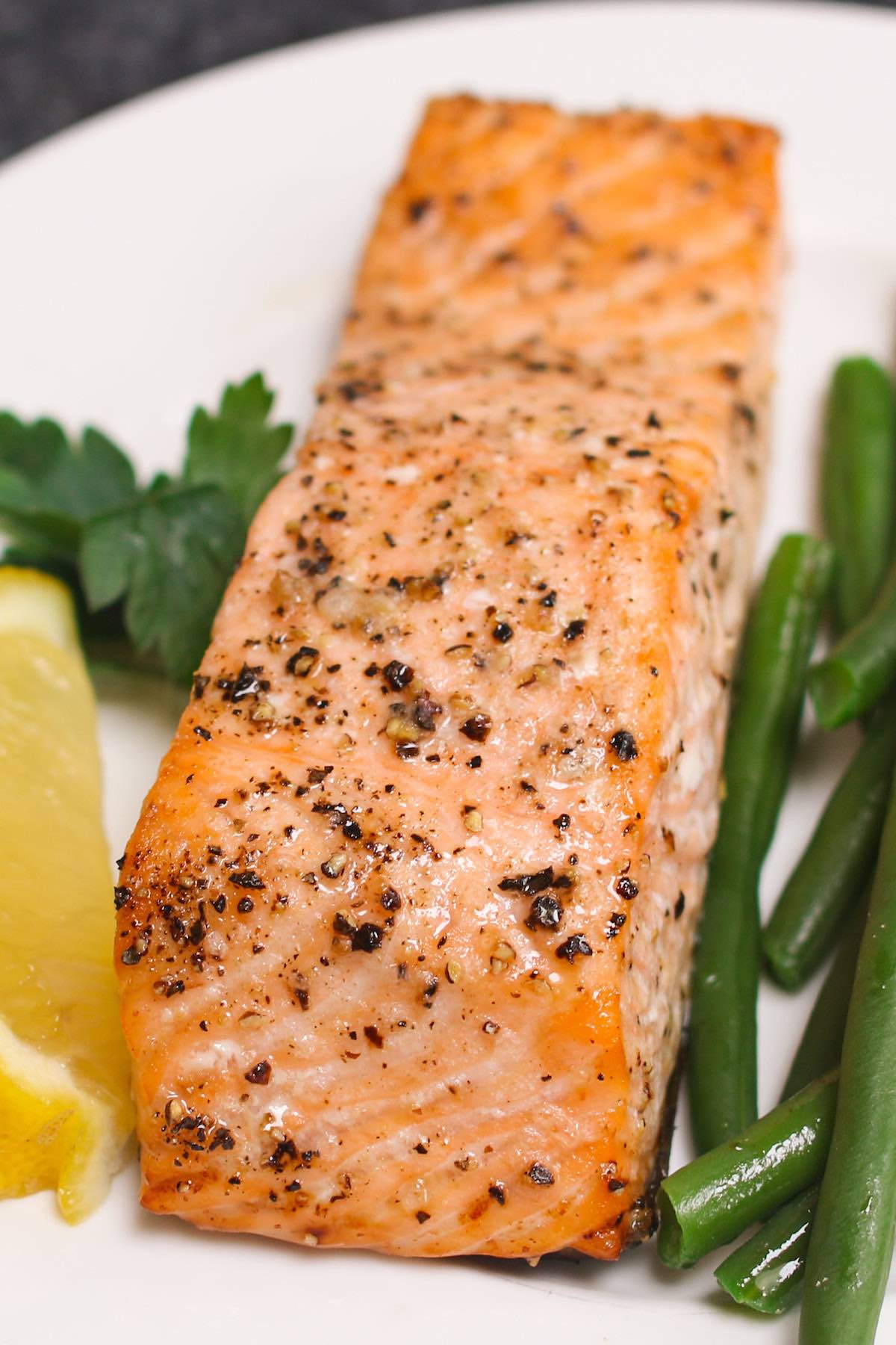 Center cut salmon fillet that's been baked to perfection featuring a golden exterior and served with green beans