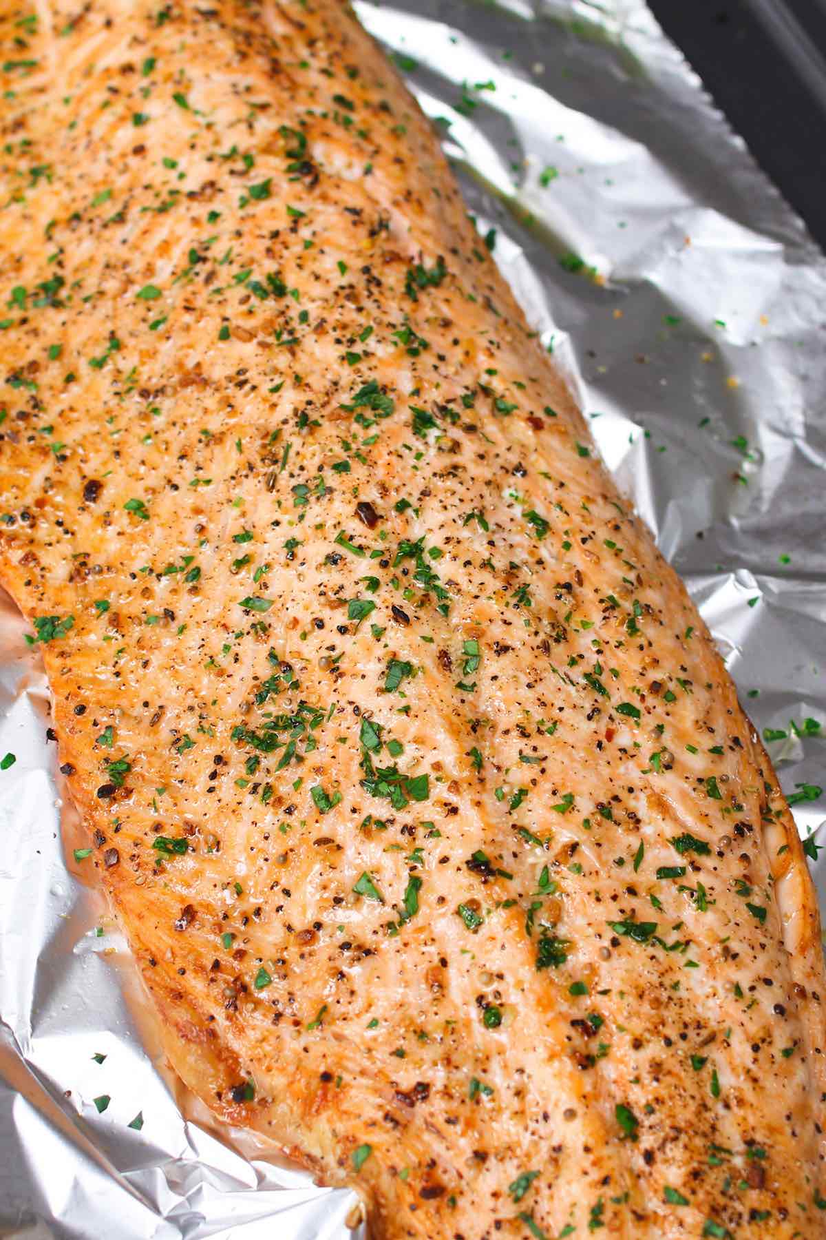 Baked Salmon fresh out of the oven with a crisp exterior and fresh herbs on top