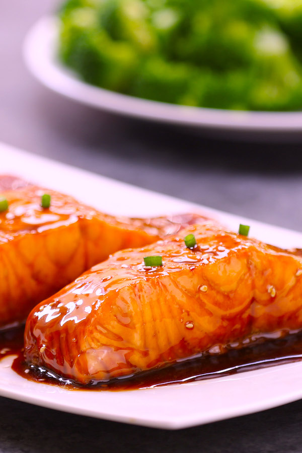 Closeup photo of center cuts of salmon on a serving plate after being baked with a simple 4-ingredient honey garlic sauce.