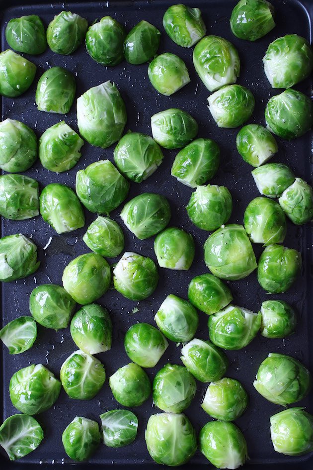 Brussel sprouts are placed into the sheet pan with a single layer with the flat sides facing down before roasting.