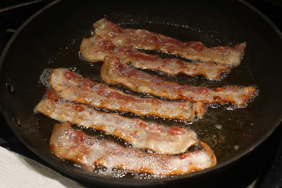 Frying bacon in a pan until crispy
