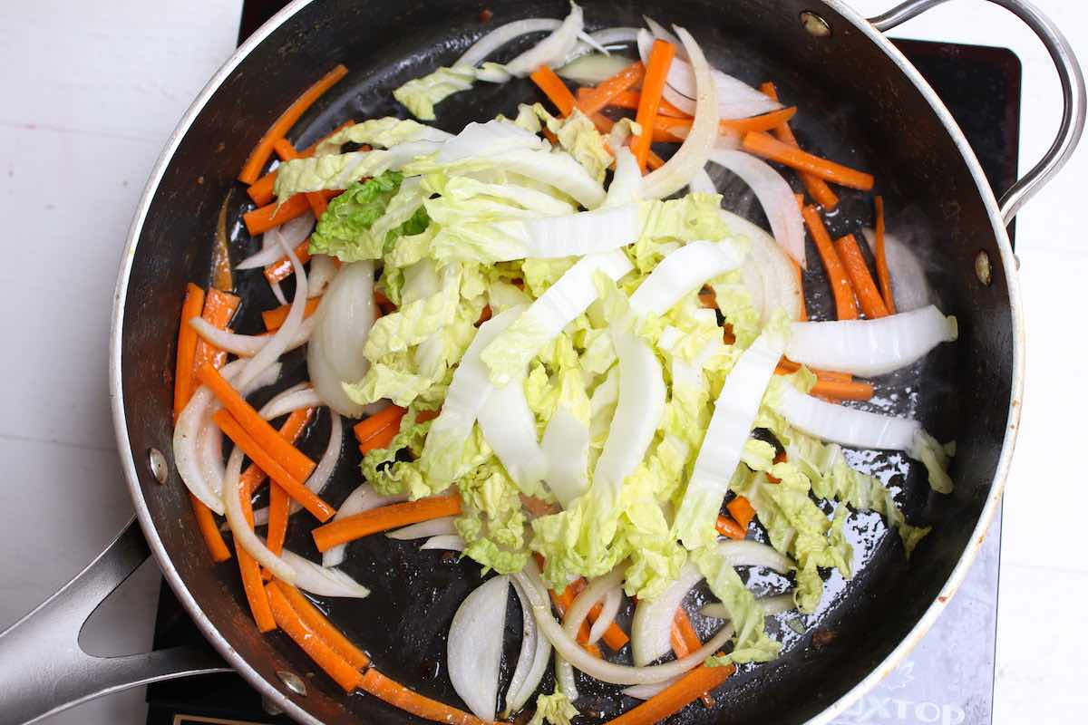 Stir frying the vegetables when making Singapore fried noodles