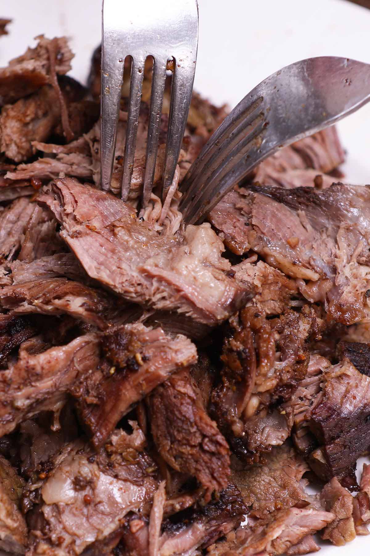Pulling smoked beef apart using two forks