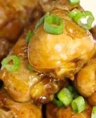 Coca Cola Chicken pan fried to tender and juicy perfection and drizzled with its own sweet and savory sauce on a serving plate, garnished with green onion for an easy party appetizer or dinner idea