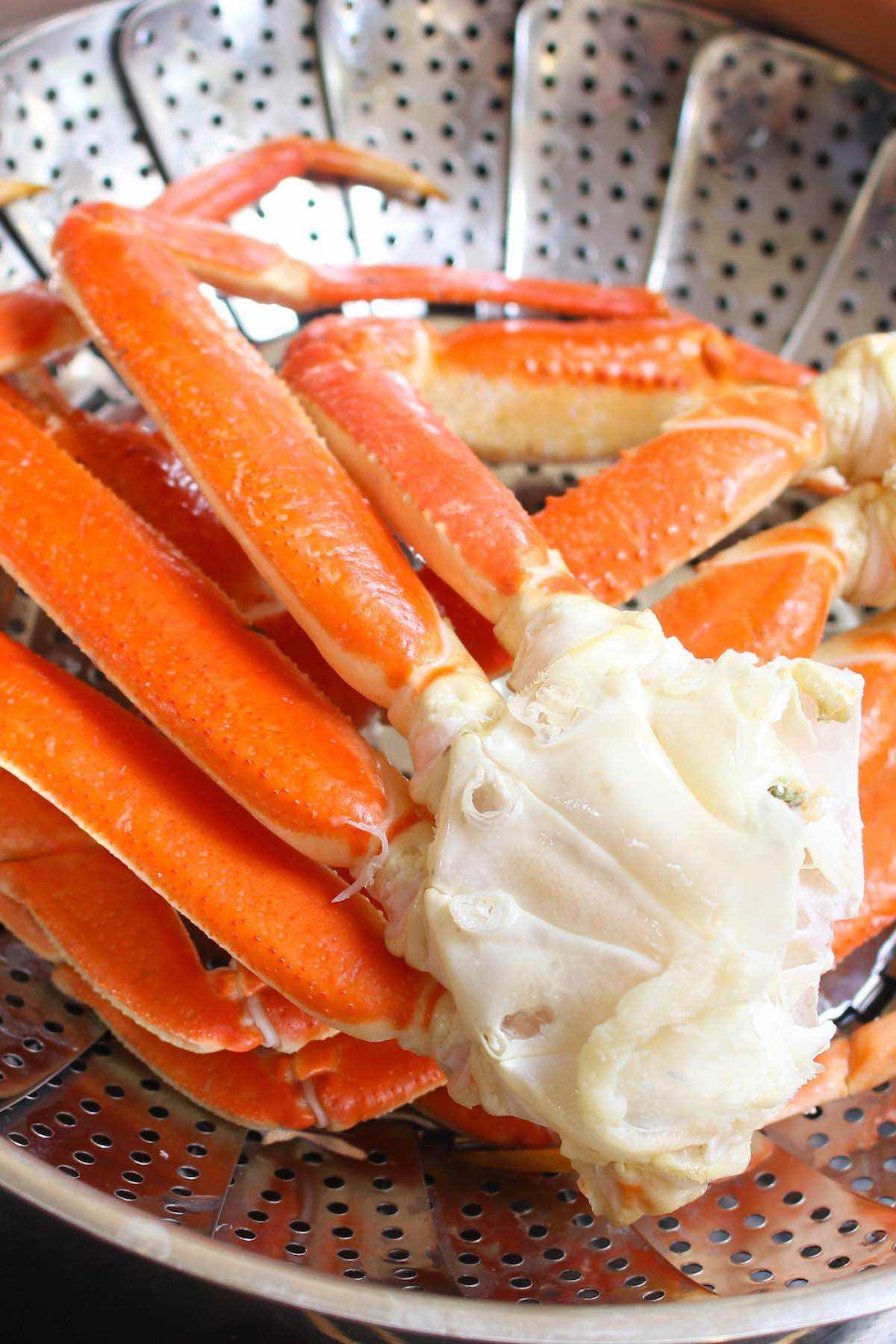 Steaming crab legs in a steamer basket inside of a pot.