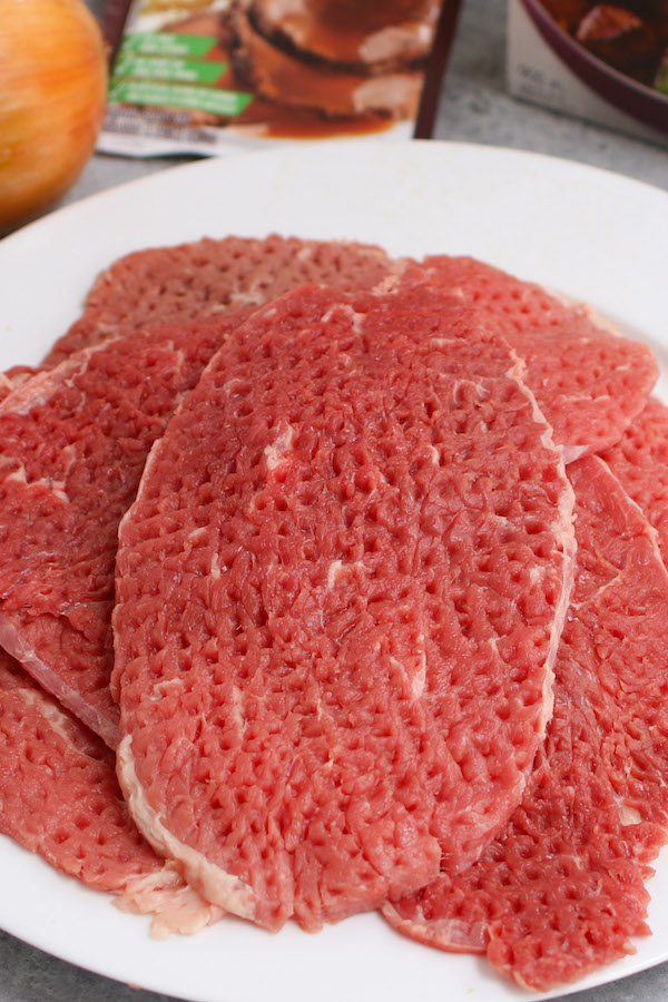 Cube steak is a sirloin or top round steak that has been tenderized by pounding it with a meat tenderizer. This process helps to tenderize and flatten the tough cut of meat and leaves small cube-shaped indentations hence the name