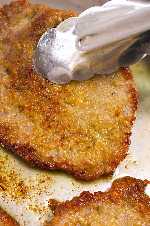 Cubed steak breaded and pan-fried to golden brown in a skillet before adding to the crock pot.