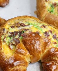 Breakfast Croissant Boats – crispy bacon, fluffy egg and melted cheddar cheese baked in croissant breakfast boats! A quick and easy recipe that’s ready in 30 minutes and feeds a crowd! Perfect for breakfast and brunch. So delicious! Video recipe. | Tipbuzz.com