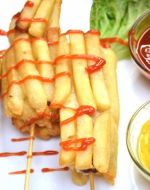 Fried hot dogs on a serving plate with ketchup ad mustard dipping sauces for the perfect party appetizer