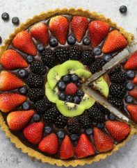 No Bake Chocolate Fruit Pizza – simple and decadent fruit tart that’s unbelievably beautiful and delicious. It has a graham cracker crust and smooth creamy chocolate filling, topped with fresh fruits. All you need is a few simple ingredients: graham cracker, butter, chocolate, heavy cream and fresh fruits. A simple dessert you whole family will be obsessed with. Perfect for summer parties. Quick and easy, dessert recipe. vegetarian. Video recipe. | tipbuzz.com