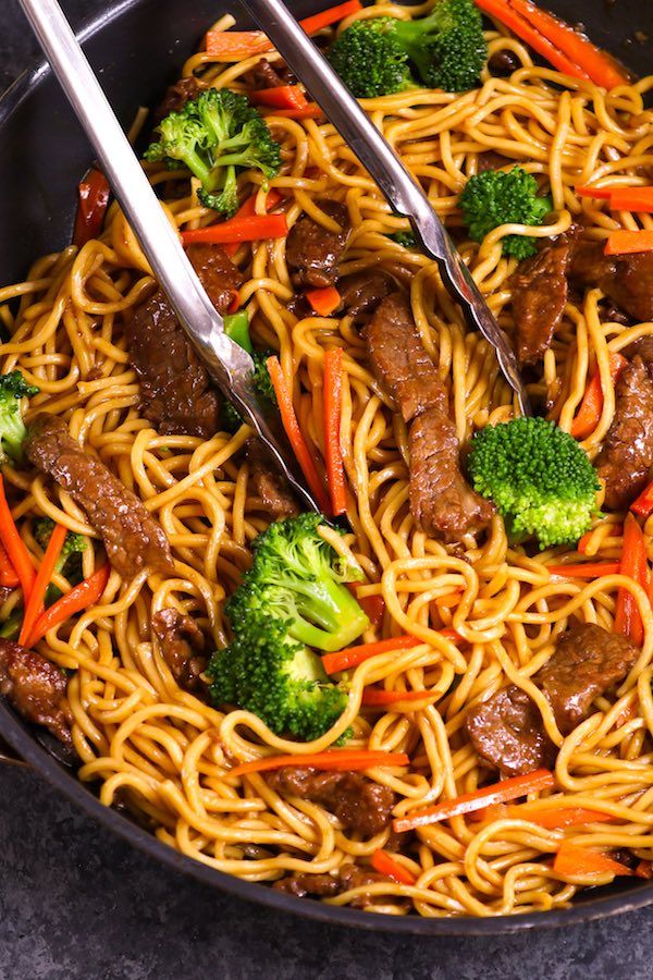 Overhead view of beef and broccoli lo mein in a skillet after being tossed in lo mein sauce.