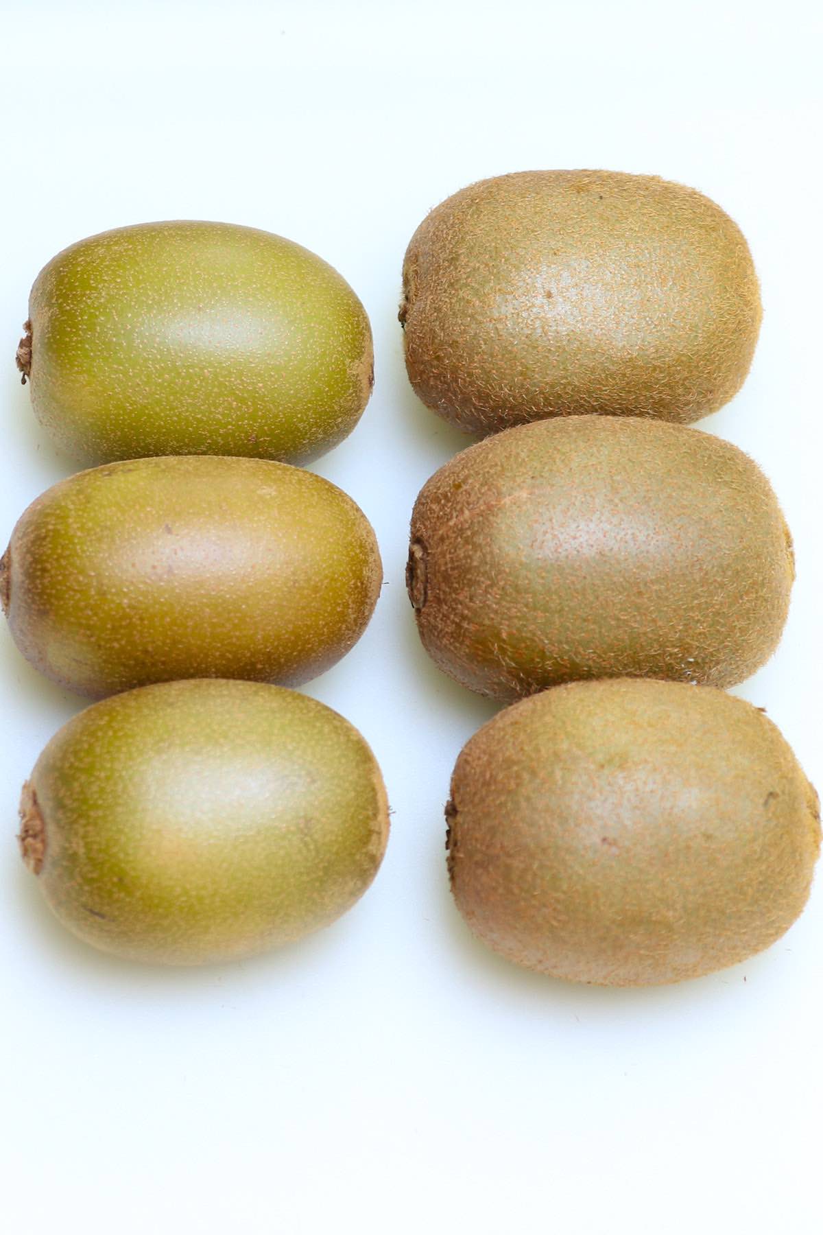 Side by side comparison of golden kiwi and green kiwi showing the differences in size, skin and color