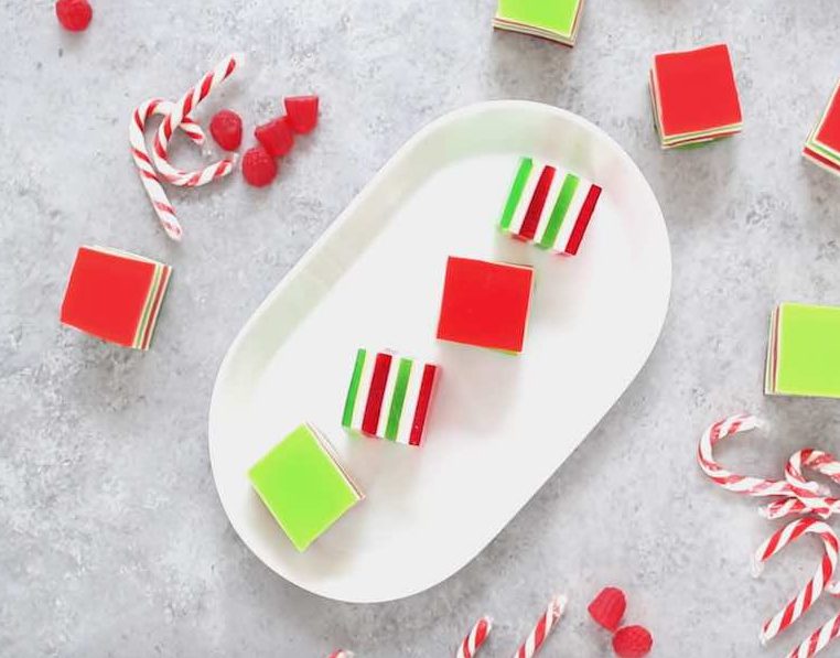 Christmas jello shots on a serving platter showing off their beautiful red, green and white layers