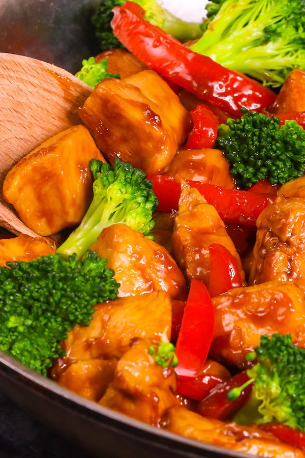 Closeup of cubed chicken breast and vegetables coated in honey garlic sauce for a delicious chicken vegetable stir fry