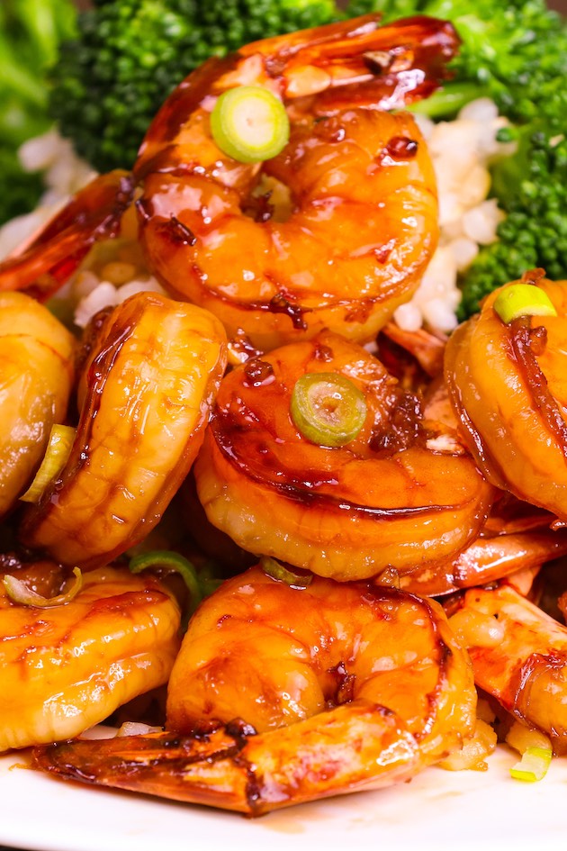 Closeup of honey garlic shrimp perfectly glazed and served on a bed of steamed rice with a side of broccoli