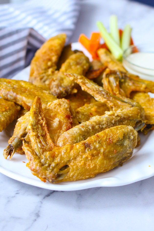 Crispy baked chicken wings on a serving platter with carrots, celery and ranch dip