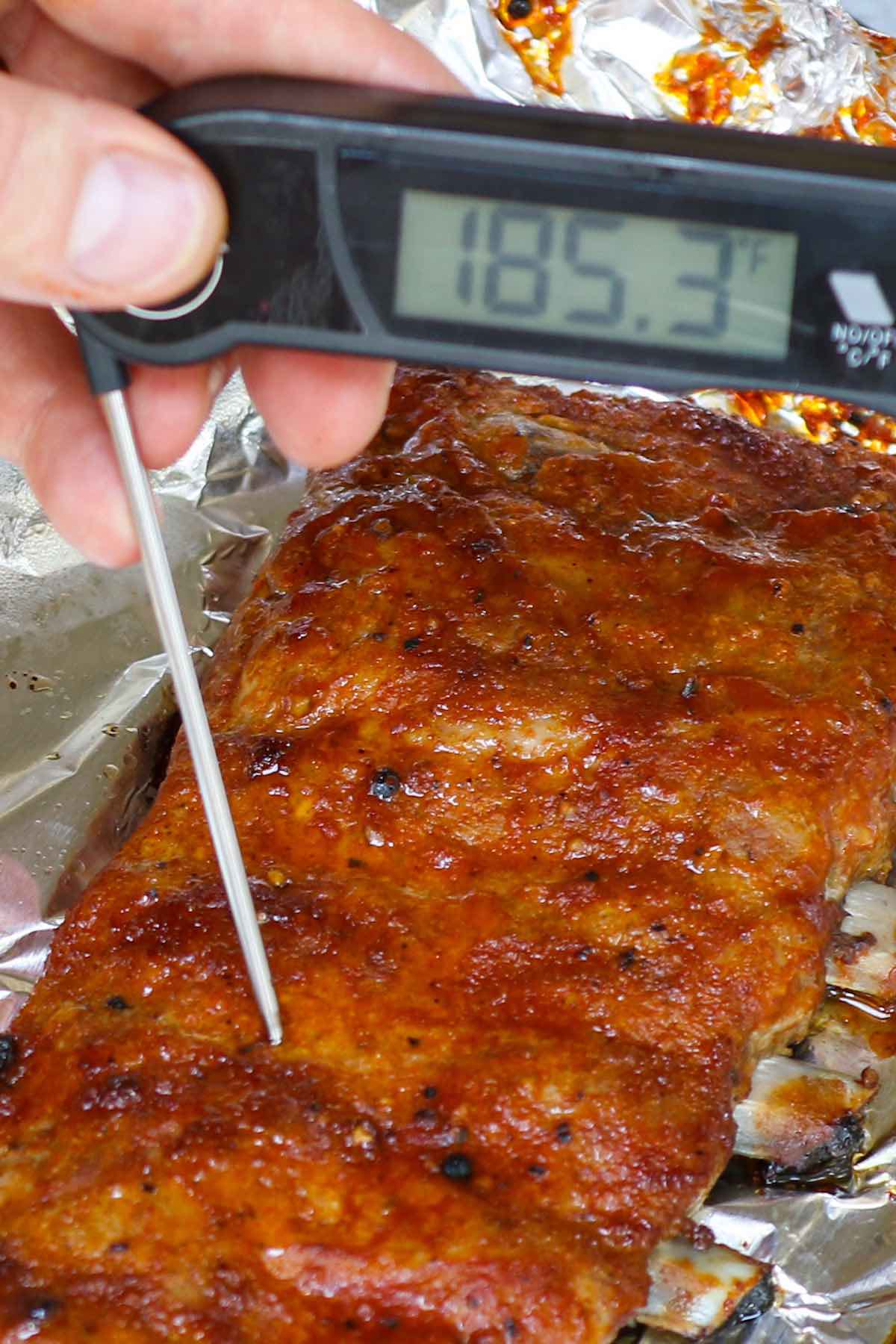 Checking the internal temperature of ribs and getting a reading of 185°F showing they are ready