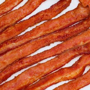Learn how long to cook bacon in the oven with this handy guide! We also cover tips on how to cook bacon easily including temperature, cuts, tips and tricks. Whether you prefer crispy or chewy oven baked bacon, read on for all the tips you need!