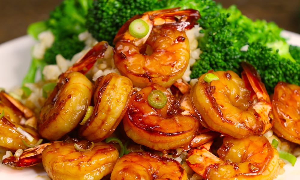 Jumbo honey garlic shrimp served on brown rice with broccoli and garnished with sliced green onions