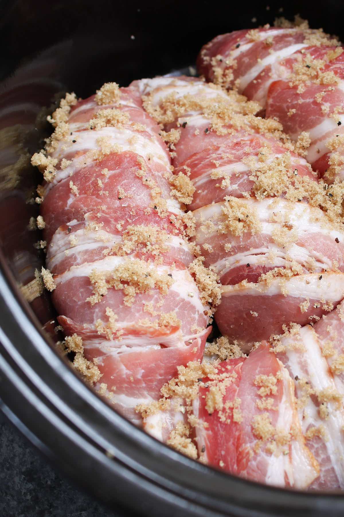 Brown sugar bacon wrapped chicken breasts in the crock pot ready for cooking