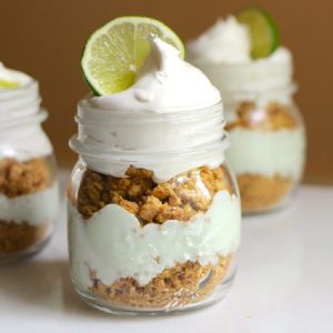 No Bake Key Lime Pie In A Jar – smooth, creamy and tangy key lime cheesecake is layered between crunchy crashed graham crackers. Served in individual mason jars. It’s so easy and comes together in 10 minutes. All you need is a few simple ingredients: crushed graham crackers, butter, cream cheese, condensed milk, vanilla greek yogurt, key lime juice, green food coloring, whipped topping and slices of lime to garnish. So good! Quick and easy, no bake dessert, vegetarian. Video recipe. | tipbuzz.com