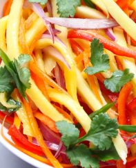 Mango Salad in a serving bowl for a quick summer salad recipe that everyone always loves! A rich and creamy Peanut Dressing is tossed with fresh mango, carrots, red bell pepper, red onions and crunchy peanuts to give you the most refreshing salad