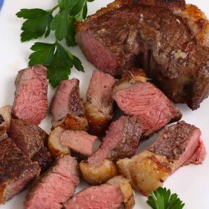 Picanha steak cooked medium on a serving platter with parsley