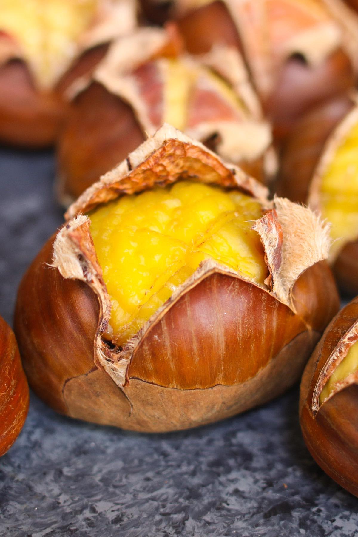 Roasted chestnuts are a healthy and hearty snack with a sweet, nutty flavor. Learn how to roast chestnuts in an oven, pan or on fire this holiday season. Scoring and soaking before roasting is the key to making this tree nut easier to eat. I’ll also show you how to peel skins easily so you can enjoy delicious chestnuts!