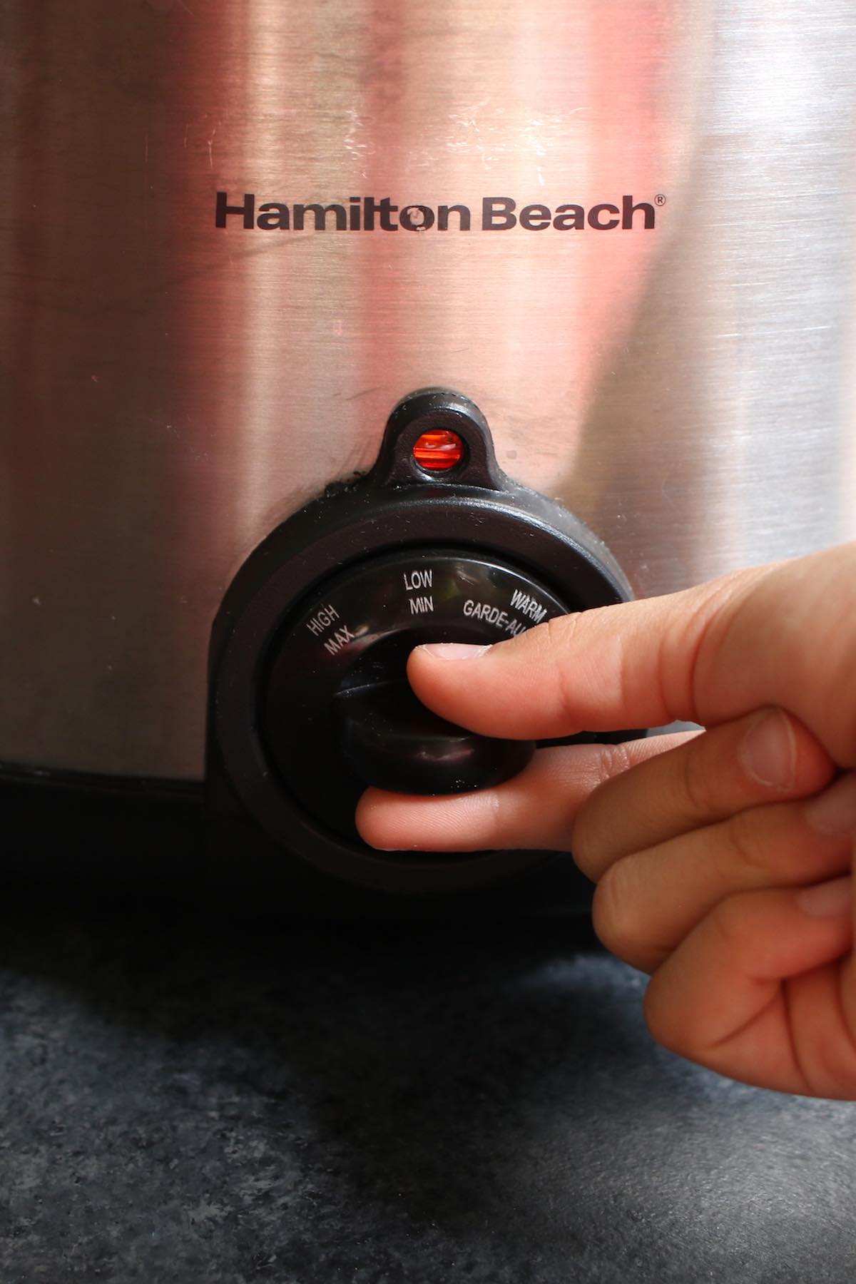 Adjusting the crock pot temperature between LOW, HIGH and WARM