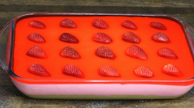 This is a photo of the completed strawberry jello cake in a rectangular glass baking dish so you can see the three layers
