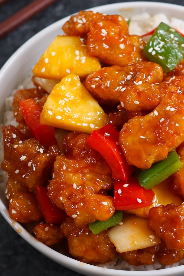 Chinese stir fried chicken garnished with sesame seeds and served in a rice bowl