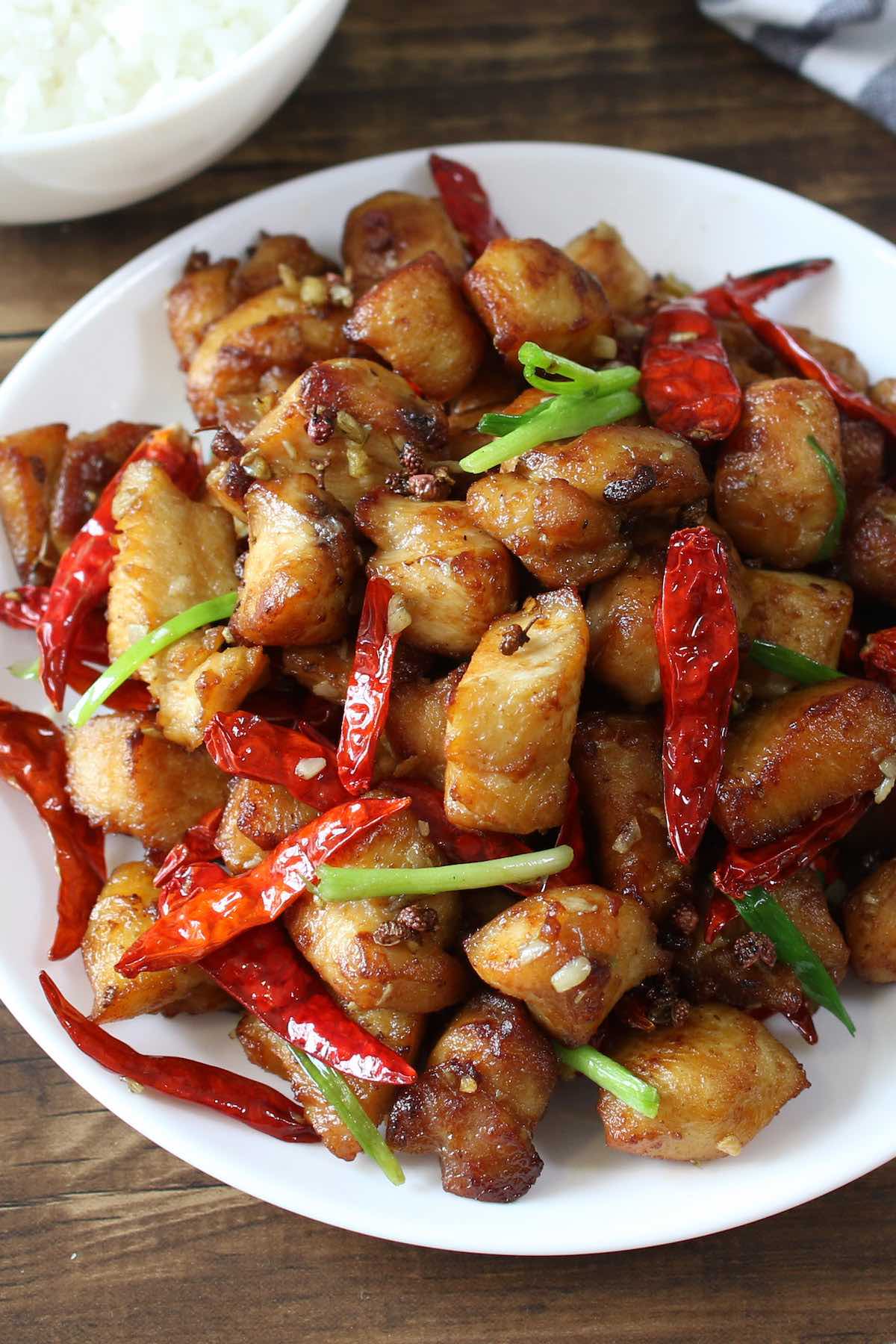 Szechuan chicken cooked with whole Szechuan peppercorns on a serving plate.