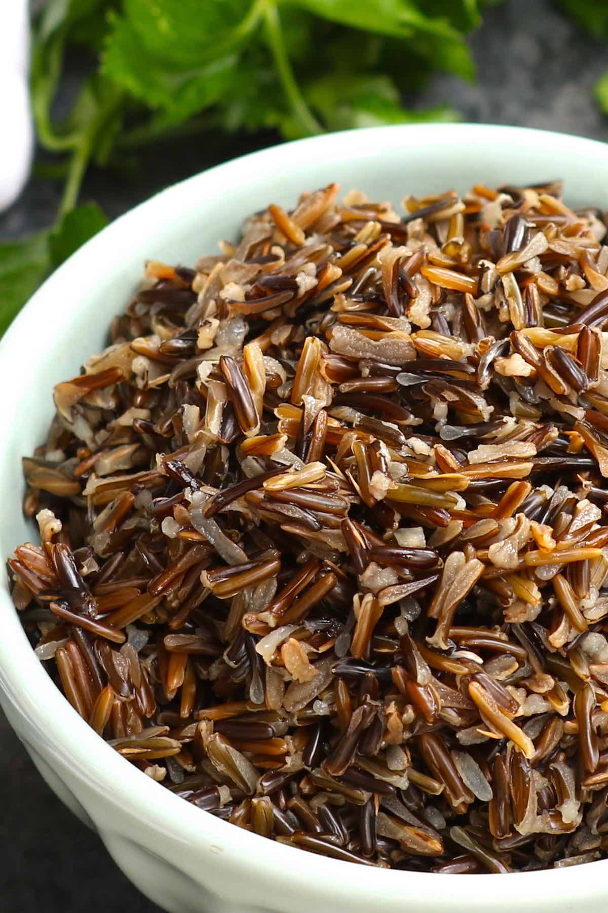 Perfectly cooked wild rice in a serving bowl showing its fluffy, chewy texture and walnut color