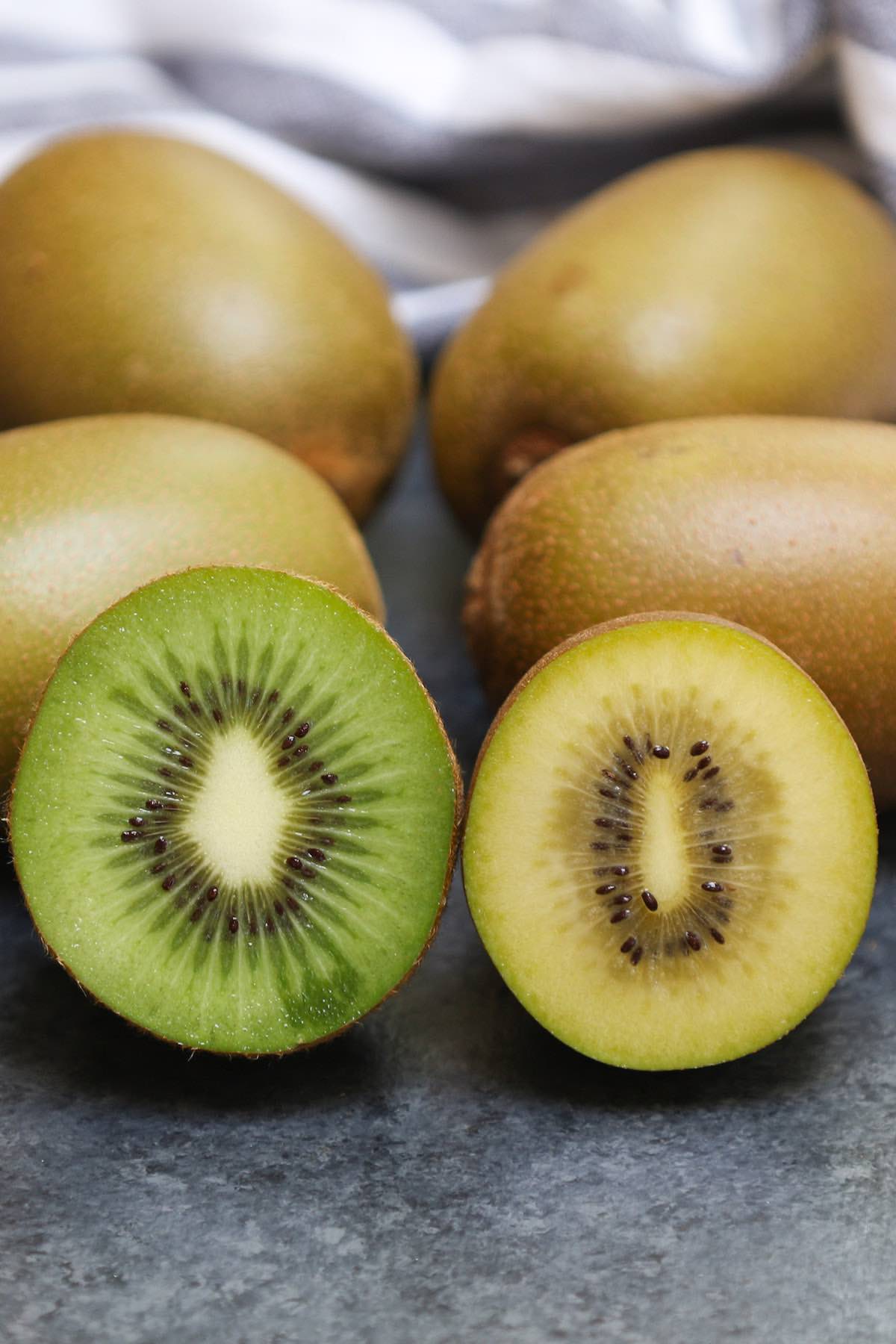 Side-by-side comparison of green kiwifruit and yellow kiwi showing the different colors of the flesh
