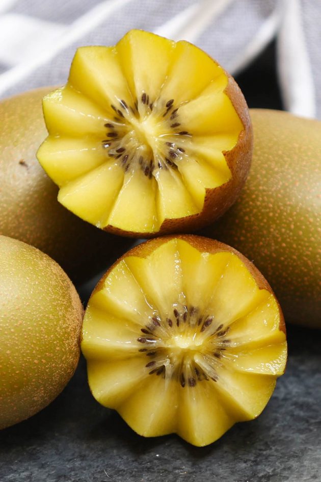 Yellow kiwi cut in a decorative floral pattern showing off its color